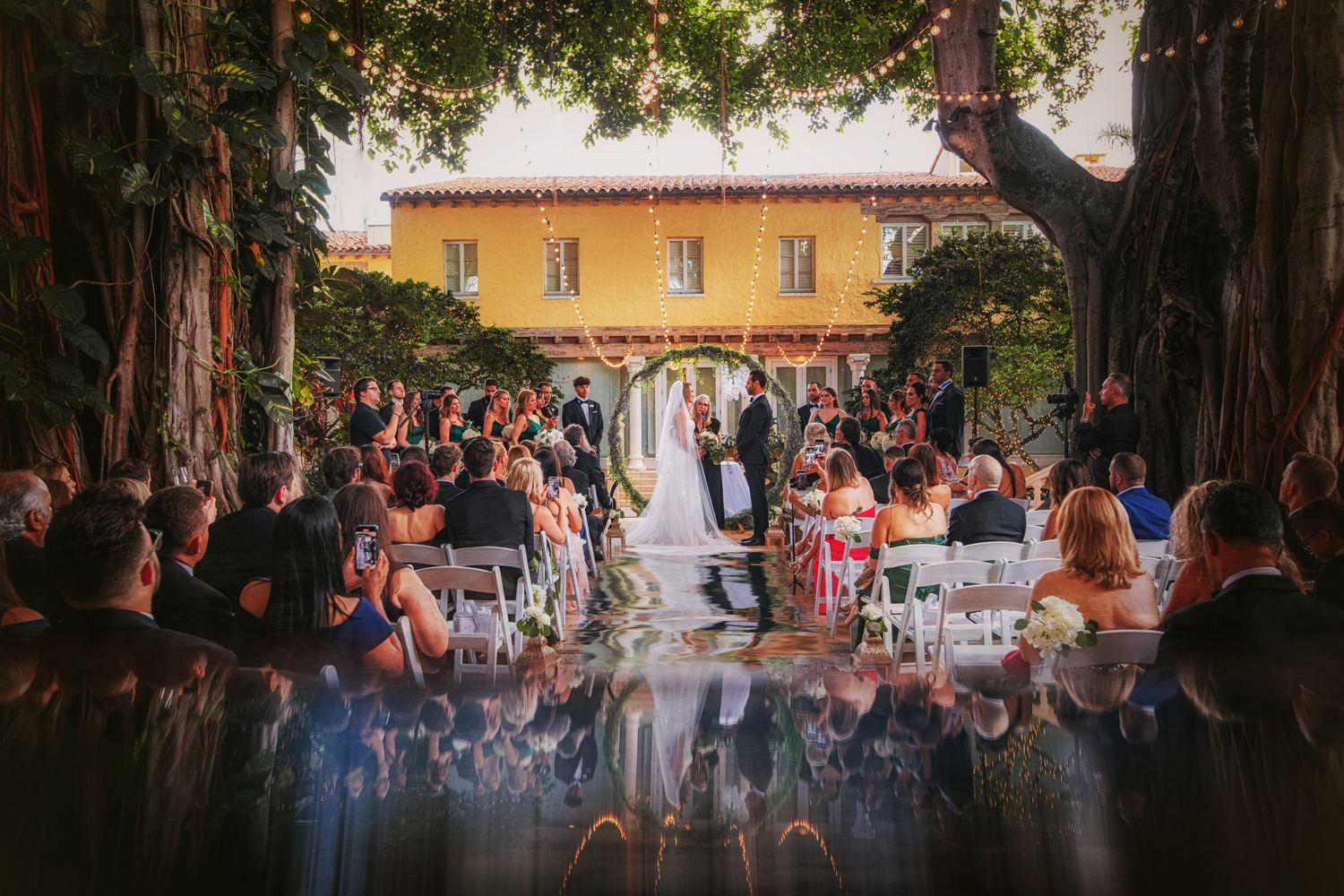 Luxury Wedding Ceremony at The Addison, West Palm Beach A breathtaking outdoor wedding ceremony at The Addison in West Palm Beach, featuring a romantic floral arch, glowing string lights, and a dreamy fine art aesthetic. Captured by Victoria Machin Photography and meticulously planned by event designer Roxy Quevedo of Zeta Event Productions, this luxury wedding exudes elegance and sophistication.