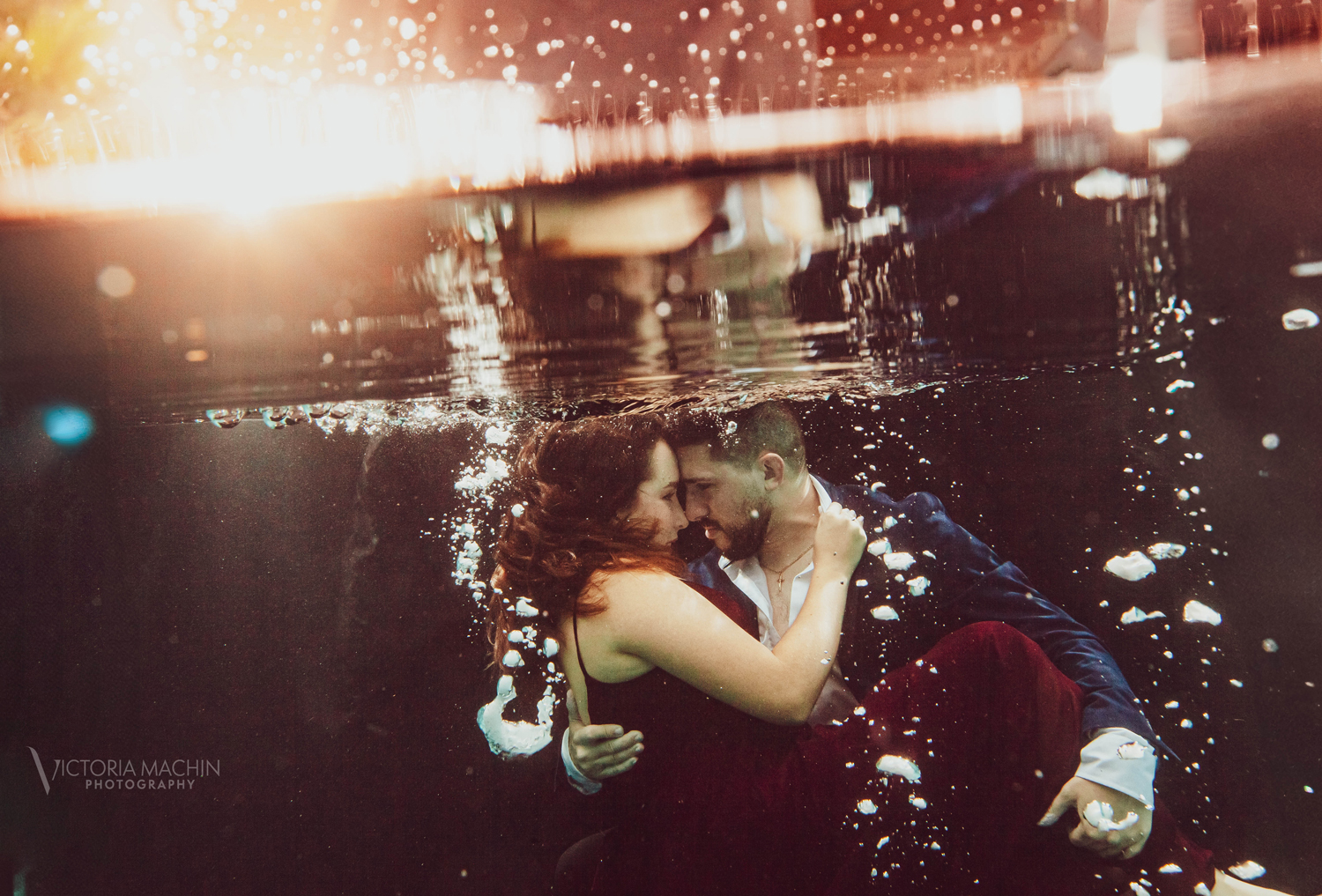 Engaged couple holding each other underwater in a romantic embrace during an artistic underwater engagement photoshoot in Miami by Victoria Machin Photography.
