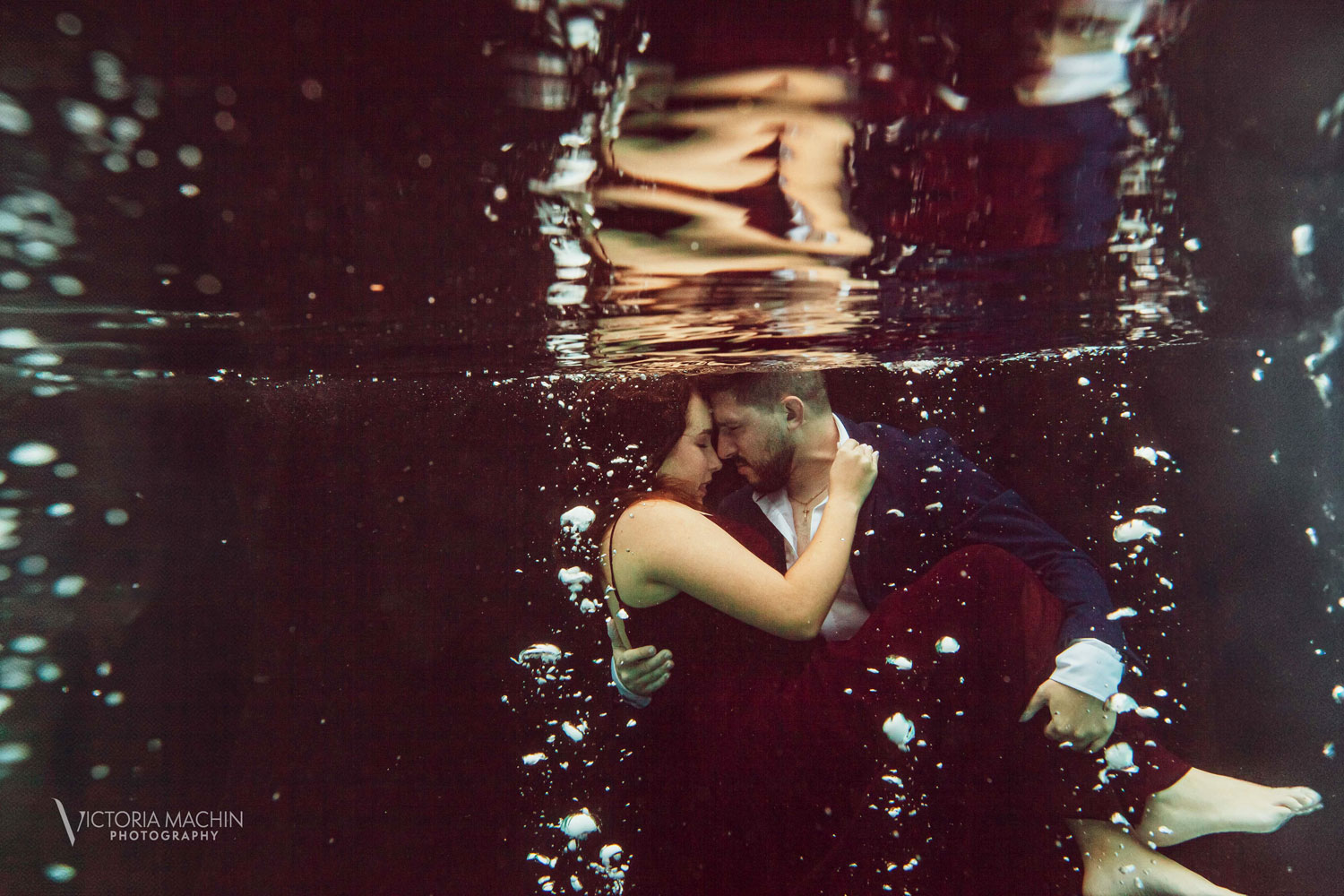 Engaged couple holding each other underwater in a romantic embrace during an artistic underwater engagement photoshoot in Miami by Victoria Machin Photography.