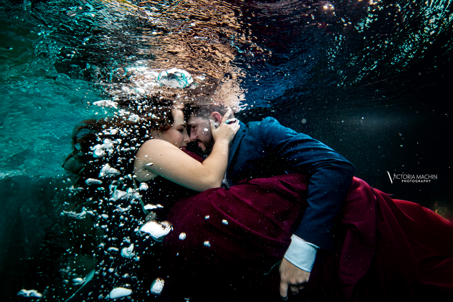 Engaged couple holding each other underwater in a romantic embrace during an artistic underwater engagement photoshoot in Miami by Victoria Machin Photography.