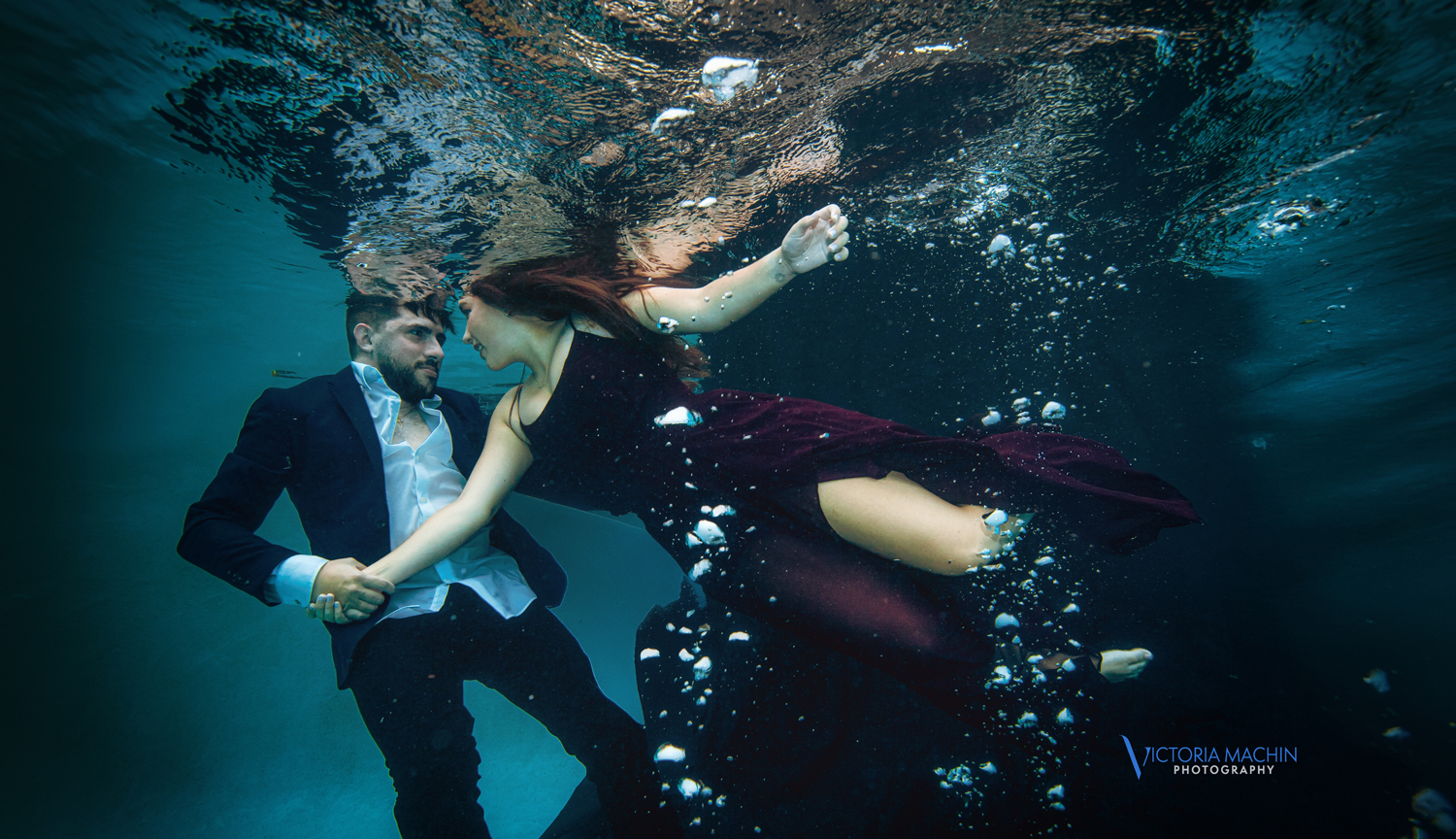 Engaged couple holding each other underwater in a romantic embrace during an artistic underwater engagement photoshoot in Miami by Victoria Machin Photography.
