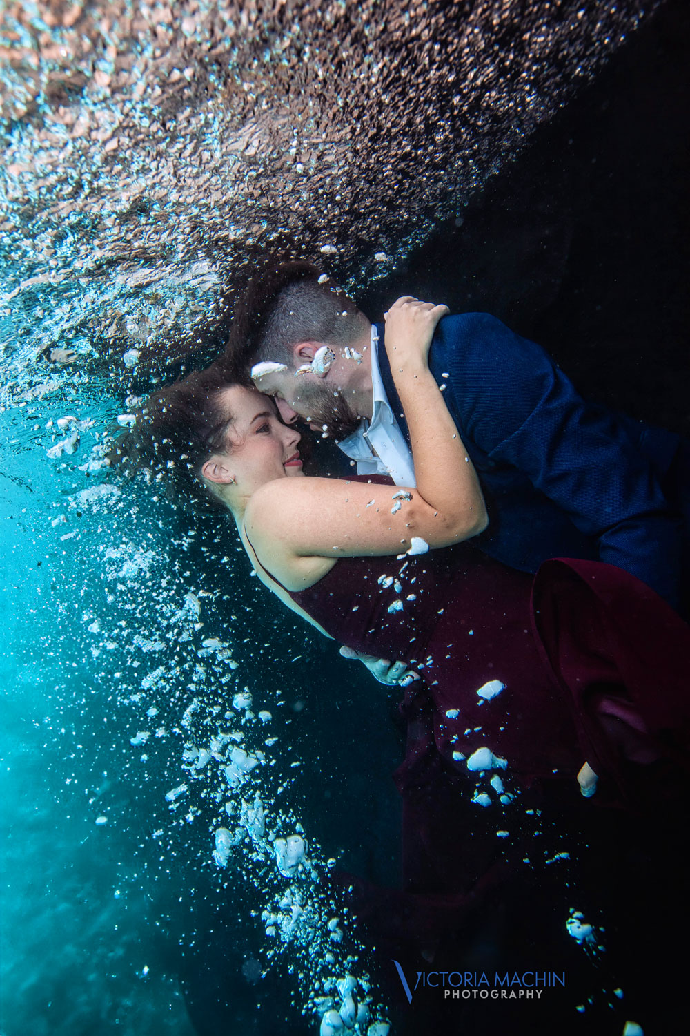 Engaged couple holding each other underwater in a romantic embrace during an artistic underwater engagement photoshoot in Miami by Victoria Machin Photography.