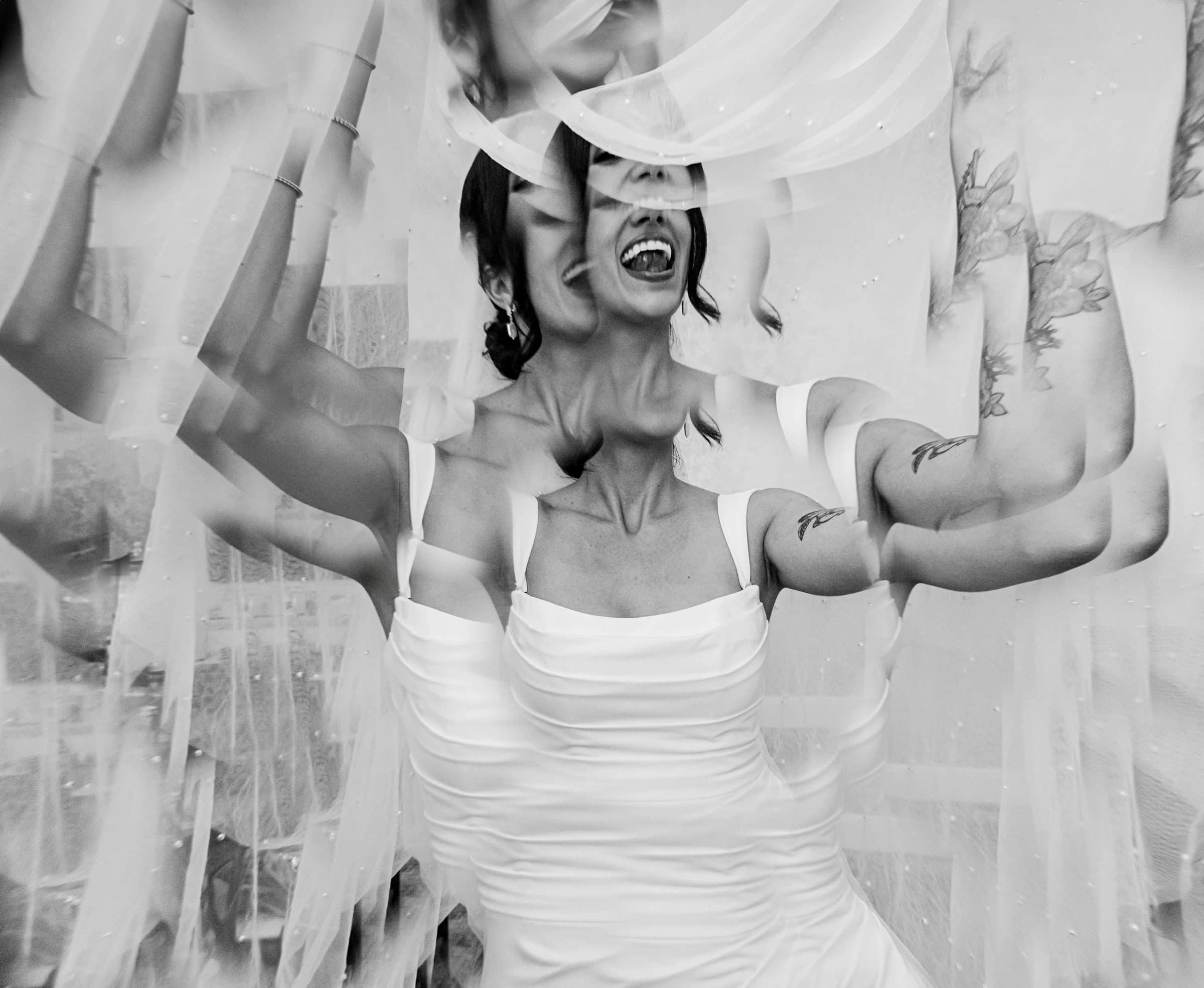 Bride laughing beneath her veil, multiplied through a prism, black and white