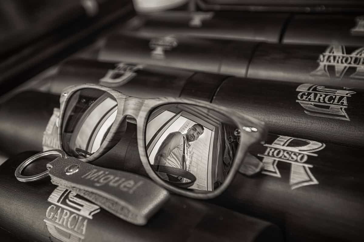Engraved cigar tubes and sunglasses reflecting the groom, groomsmen gifts in black and white