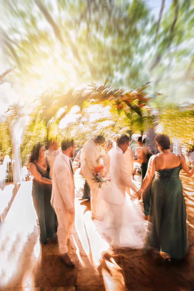 Wedding party in a garden caught in zoom blur and golden light