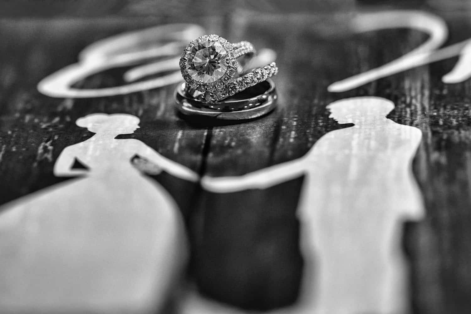 Wedding rings between bride and groom silhouettes, black and white